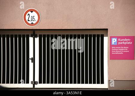 Un portail en fer verrouillé devant la sortie du parking d'un parking souterrain avec des places de parking pour les clients Banque D'Images