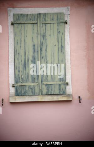 Un vieux volet fermé en bois et fané sur une fenêtre nostalgique Banque D'Images
