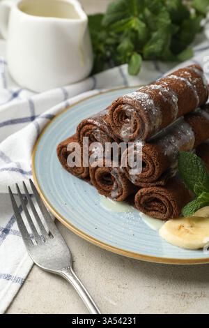 Délicieuses crêpes au chocolat à la banane et aux myrtilles servies sur une table lumineuse, en gros plan Banque D'Images