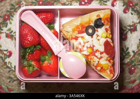 Boîte à lunch contenant de la pizza et des fraises fraîches prêtes à manger Banque D'Images