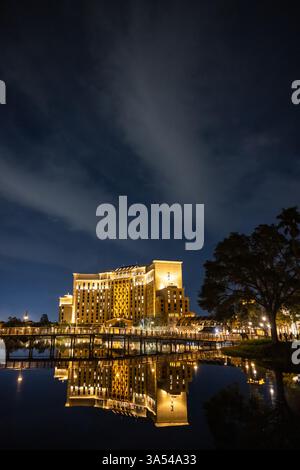 Gran Destino Tower illuminé la nuit avec des reflets sur le Lago Dorado au Disney’s Coronado Springs Resort, Lake Buena Vista, Floride. Banque D'Images