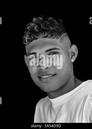 Portrait monochrome d'un beau jeune colombien portant une boucle d'oreille Banque D'Images