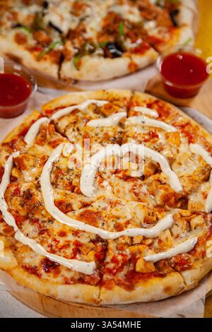 Poulet tikka masala pizza en croûte mince cuite au four à bois Banque D'Images