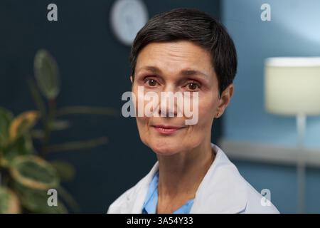 Portrait d'une femme senior portant un manteau de laboratoire blanc et souriant Banque D'Images