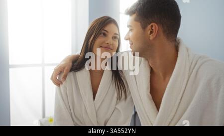Homme et femme dans une relation amoureuse dans un spa de bien-être portant des peignoirs dans un cadre intérieur Banque D'Images
