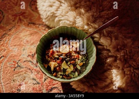 Bol de granola sain sur tapis à la lumière du soleil Banque D'Images