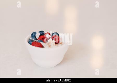 Un bol minimaliste de yaourt à la noix de coco garni de baies, de cinna Banque D'Images