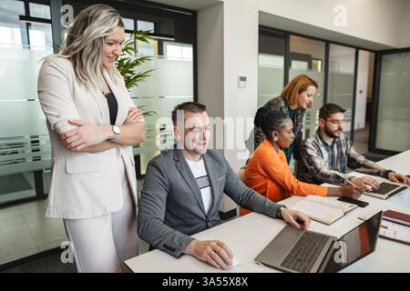 Groupe de personnes assis à table avec des ordinateurs portables Banque D'Images