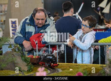 Olomouc, République tchèque. 21 mars 2025. Les modélisateurs aéronautiques, navals et automobiles ont préparé leurs expositions à la veille de la 23ème édition de l'exposition interactive for Model 2025, axée sur les modèles, la collecte et les technologies numériques, les jeux, les jouets et les kits, Olomouc, République tchèque, 21 mars 2025. Un homme et un garçon regardent le chemin de fer miniature de Jan Bartos. Crédit : Ludek Perina/CTK photo/Alamy Live News Banque D'Images
