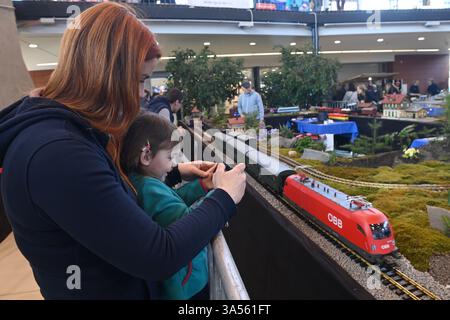 Olomouc, République tchèque. 21 mars 2025. Les modélisateurs aéronautiques, navals et automobiles ont préparé leurs expositions à la veille de la 23ème édition de l'exposition interactive for Model 2025, axée sur les modèles, la collecte et les technologies numériques, les jeux, les jouets et les kits, Olomouc, République tchèque, 21 mars 2025. Une femme avec un enfant prend une photo du chemin de fer de jardin modèle de Jan Bartos. Crédit : Ludek Perina/CTK photo/Alamy Live News Banque D'Images