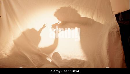Jouets, parent et enfant avec ombre pour jouer, scénario imaginaire et liaison ensemble dans la tente. Maison, personne et enfant avec des jeux d'enfance pour la fantaisie Banque D'Images