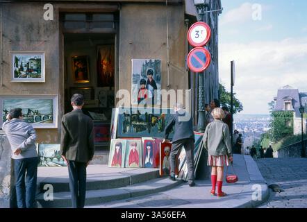 Boutique du coin d'artiste à Montmartre, Paris, été 1963. Les passants regardent les peintures exposées à l'extérieur. Vacances en France. Vacances en France. Banque D'Images