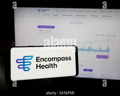 Stuttgart, Allemagne - 11-07-2024 : personne tenant un smartphone avec le logo de la société américaine de soins de santé Encompass Health Corporation sur l'écran Banque D'Images