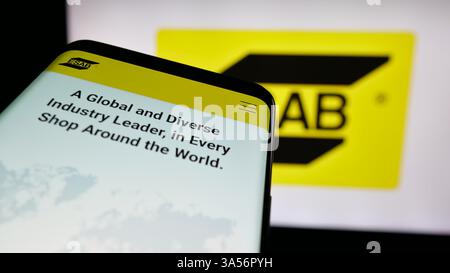 Stuttgart, Allemagne - 11-07-2024 : smartphone avec le site Web de la société industrielle ESAB Corporation sur l'écran devant le logo de l'entreprise. Banque D'Images