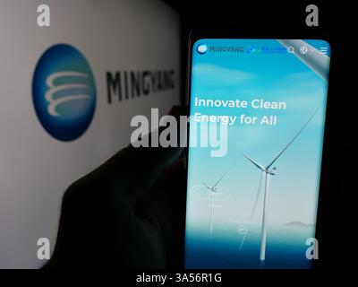 Stuttgart, Allemagne - 11-07-2024 : personne tenant le téléphone portable avec la page Web de la société chinoise Ming Yang Wind Power Group Limited sur l'écran avec le logo. Banque D'Images