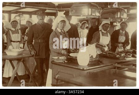 Carte postale originale de l'ère WW1 des infirmières de Vads préparant la nourriture dans une cuisine d'hôpital. Un soldat du RAMC (Royal Army Medical corps) se tient debout, posté de Maidenhead, Berkishire par un patient. C'était possiboly l'hôpital VAD (Voluntary Aid Detachment) avec du personnel civil volontaire au collège technique Maidenhead, Marlow Road. À son apogée, l'hôpital comptait plus de 200 lits et était le plus grand hôpital VAD du Berkshire. Daté / posté de Maidenhead, Berkshire, England, U.K. le 22 Oct 1915. Banque D'Images