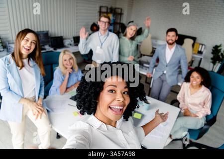 Équipe souriante de professionnels divers ayant une réunion dans un bureau moderne Banque D'Images