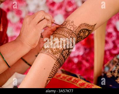 Cérémonie mehndi dans laquelle Mehndi fabrication sur la main en cours sur la main de mariée par l'artiste avant mariage indien. Banque D'Images