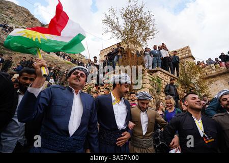 Les hommes kurdes irakiens dansent alors qu’ils célèbrent le jour du Novruz, un festival marquant le premier jour du printemps, nouvel an kurde et persan, dans la ville d’Akre, dans la région du Kurdistan. Nowruz, également connu sous le nom de nouvel an kurde et persan, est une célébration séculaire marquant l'arrivée du printemps et le début de la nouvelle année dans le calendrier persan. Observé par des millions de personnes à travers le moyen-Orient, l'Asie centrale, et au-delà, il symbolise le renouveau, l'espoir, et le triomphe de la lumière sur les ténèbres. Le festival comprend des traditions telles que des réunions de famille, des repas festifs et la préparation d'un onglet 'Haft-Seen' Banque D'Images