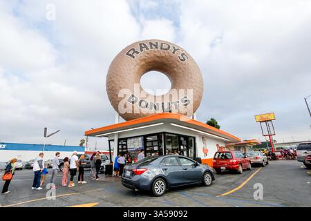 Los Angeles, Californie, États-Unis - 07-19-07 2019 : une vue de plusieurs voitures et personnes qui font la queue pour commander des friandises sucrées de Randy's Donuts. Banque D'Images