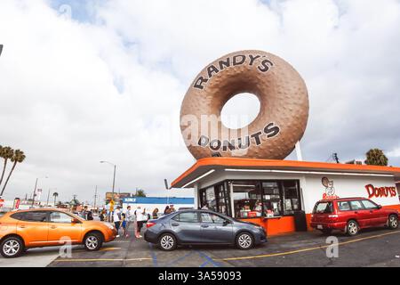 Los Angeles, Californie, États-Unis - 07-19-07 2019 : une vue de plusieurs voitures et personnes qui font la queue pour commander des friandises sucrées de Randy's Donuts. Banque D'Images