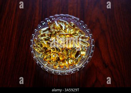 capsules de couleur dorée dans un bol en verre Banque D'Images