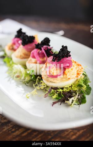 Vue rapprochée d'une assiette d'œufs dévorés garnis. Banque D'Images