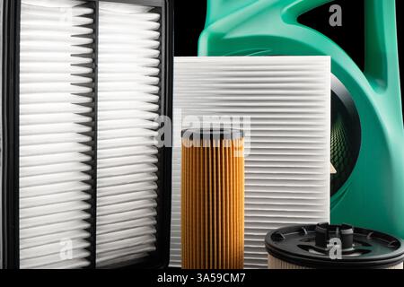 Huile moteur de voiture et filtres isolés sur fond noir. Huile de voiture, air, filtres à carburant et huile de moteur dans la boîte en plastique isolé. Pièces de rechange de qualité pour voiture Banque D'Images