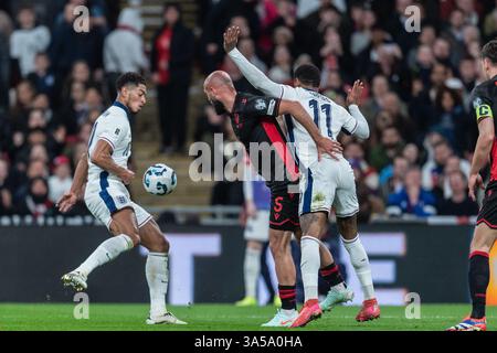 Jude Bellingham, d’Angleterre, prend le ballon alors qu’Arlind Ajeti, d’Albanie, retient Marcus Rashford, d’Angleterre, lors du match de qualification de la Coupe du monde de l’UEFA 2026 opposant l’Angleterre et l’Albanie au stade de Wembley, Londres, Angleterre, le 21 mars 2025. Photo de Grant Winter. Utilisation éditoriale uniquement, licence requise pour une utilisation commerciale. Aucune utilisation dans les Paris, les jeux ou les publications d'un club/ligue/joueur. Crédit : UK Sports pics Ltd/Alamy Live News Banque D'Images