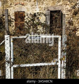 Ancienne maison abandonnée dans le Puy de Dôme avec un panneau d'avertissement dans un hameau calme du parc Livradois Forez, France Banque D'Images