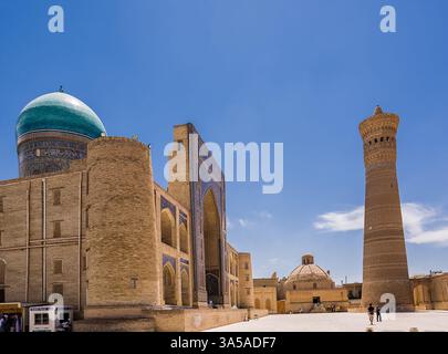 Boukhara, Ouzbékistan - 09 juillet 2024 : place ancienne avec le minaret et les portails de la madrassa Kalon Banque D'Images