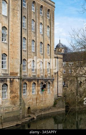 Nettoyeur de fenêtres sur l'ancien bâtiment du moulin sur la rivière Avon à Bradford sur Avon, Wiltshire, Angleterre Banque D'Images