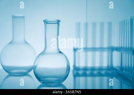 Verrerie de laboratoire sur la surface miroir sur fond clair Banque D'Images