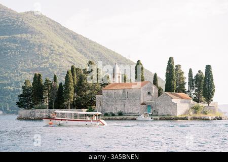 Montenegro, Perast - 08 juillet 2024 : bateau à moteur passe devant l'île George. Monténégro Banque D'Images