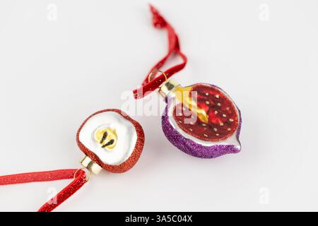 Les jouets d'arbre de Noël en forme de pomme reposent sur un fond blanc et des figues sur une corde rouge en verre jouets du nouvel an décor moderne Banque D'Images