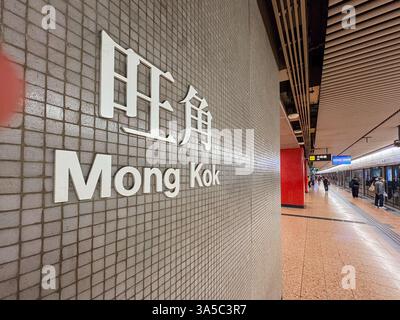 Panneau pour la station MTR Mong Kok à Hong Kong, montrant le nom de la station en anglais et en chinois sur un mur carrelé. Banque D'Images