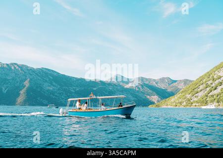 Monténégro, Kotor- 07 juillet 2024 : bateau de plaisance navigue sur la mer bleue avec des montagnes en toile de fond. Vue latérale Banque D'Images