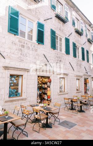 Monténégro, Kotor - 07 juillet 2024 : café de rue le long d'une vieille maison en pierre avec des boutiques de souvenirs. Kotor, Monténégro Banque D'Images
