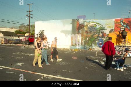 Los Angeles, CA, États-Unis, approx. 1992. Des artistes peignent une murale sur Melrose Avenue, avec d'autres personnes qui les regardent. Banque D'Images