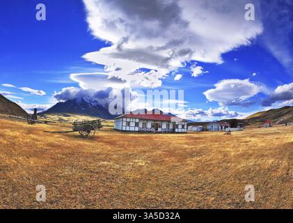 Le petit village du sud de la Patagonie. plusieurs maisons à un étage avec toits rouges. A proximité se trouve un vieux wagon avec des roues en bois Banque D'Images