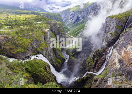 Juillet froid pluvieux en Norvège. Vaeringsfossen est l'une des cascades norvégiennes les plus célèbres. La cascade tombe dans un pittoresque étroit et profond Banque D'Images