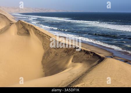 Côte atlantique de Walvis Bay, Namibie, sud de l'Afrique. Surf océanique avec vagues mousseuses. Jeep - safari à travers les immenses dunes de sable. Le concept d'extrême Banque D'Images