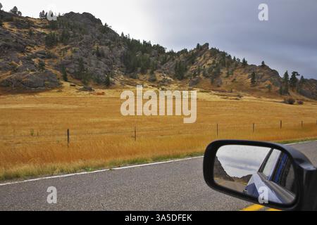 Le miroir automobile reflète la route et un paysage d'automne de l'Ouest américain Banque D'Images