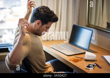 Un homme assis à la table renversa sa tasse à café. Prise de vue horizontale en intérieur Banque D'Images