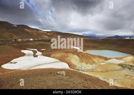 Juillet en Islande. Lac Krafla dans le cratère d'un volcan éteint. Sur les berges se trouvent les champs de neige de l'année dernière Banque D'Images