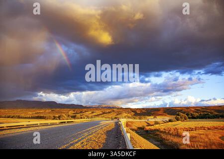 La prairie Argentine et la célèbre route de terre Ruta 40. Gigantesque orage pittoresque imprégné d'arcs-en-ciel et illuminé par le coucher du soleil. La steppe est Banque D'Images