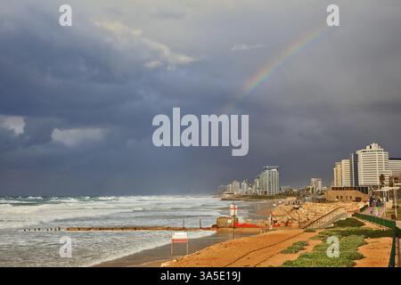 Nuage d'orage suspendu au-dessus de la mer, magnifique arc-en-ciel énorme a traversé le ciel. Promenade et plage à tel Aviv Banque D'Images