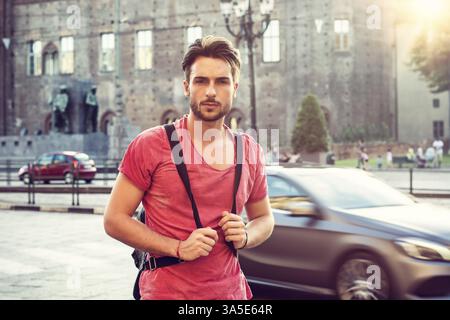 Un beau jeune homme en milieu urbain dans la ville européenne, Turin en Italie. Regarder la caméra, marcher Banque D'Images