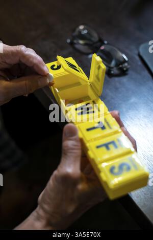Femme senior prend des pilules de la boîte. Santé et vieux concept avec des médicaments. Médicaments sur la table Banque D'Images