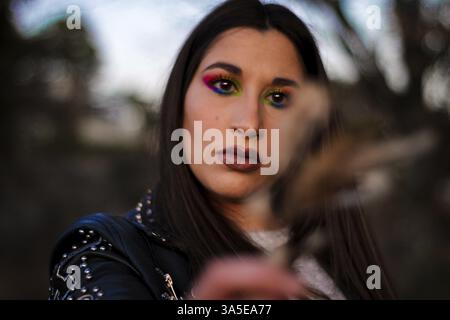 Portrait de femme maquillage avec une feuille au coucher du soleil observant la nature Banque D'Images